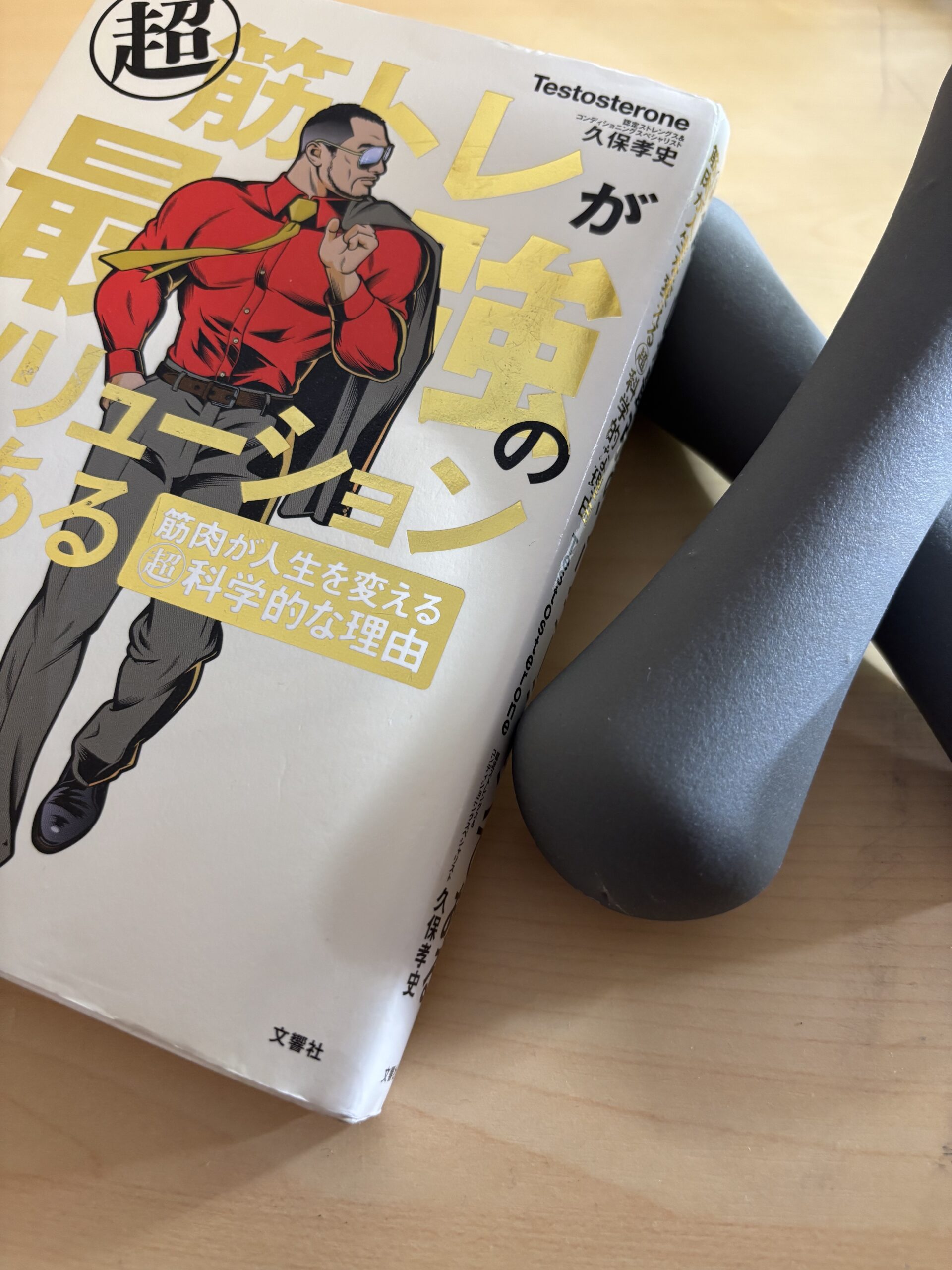 Testosterone著『超筋トレが最強のソリューションである』の本とダンベルの写真